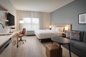 a hotel room with a bed and a living room at Hyatt Studios Huntsville in Huntsville