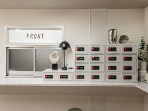 a room with a shelf with a bunch of drawers at Hale Hotel Miyakojima in Miyako-jima