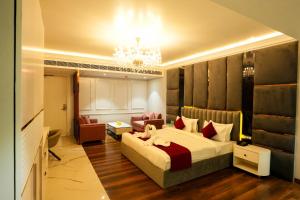 ein Hotelzimmer mit einem Bett und einem Kronleuchter in der Unterkunft Hotel Adsan Heights in Gajraula