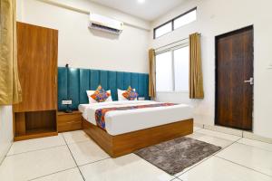 a bedroom with a king sized bed and a window at FabHotel Olive Inn in Indore