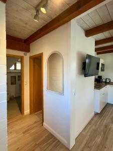a room with a white wall with a window and a tv at Kleiner Anker in Fehmarn