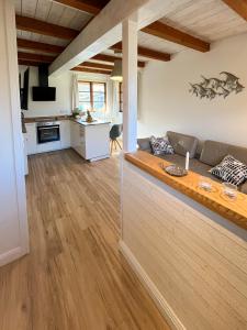 a living room with a couch and a kitchen at Kleiner Anker in Fehmarn