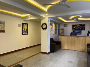 a lobby with a bar with a man at a counter at Hotel The White Castle Kargil in Kargil