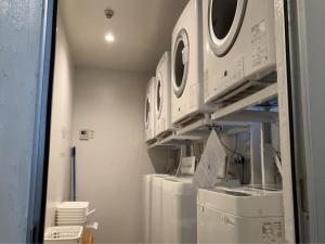 a laundry room with several washers and dryers on shelves at Hale Hotel Miyakojima in Miyako-jima +25 photos
