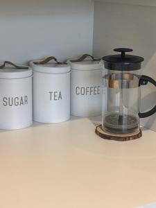 a kitchen counter with a blender and four tea containers at Sun and fun in the Bay - Home away from Home in Porirua +5 photos