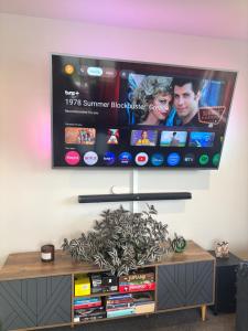 a flat screen tv hanging on a wall at Sun and fun in the Bay - Home away from Home in Porirua