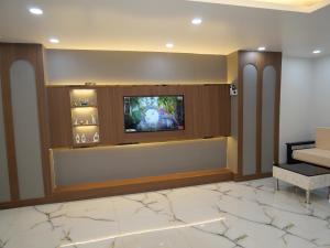 a lobby with a flat screen tv on a wall at Happy Residency in Patna +21 photos