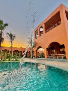 a pool with a fountain in front of a building at Arabian Coral in Ḩaḑbaram