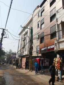a group of people walking down a street next to a building at Happy Residency in Patna