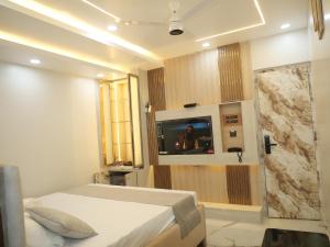 a bedroom with a bed and a tv on a wall at Happy Residency in Patna