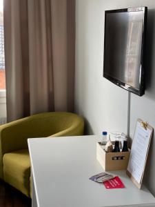 a room with a chair and a tv on a wall at Gästisbacken in Alfta