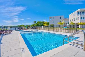 a swimming pool with a fence and a building at Chic Ocean Hideaway with Grill in Key Largo