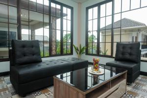 a living room with two chairs and a glass table at Urbanview Grand Lotus Hotel by RedDoorz in Purwokerto