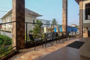 a balcony with a table and chairs on it at Urbanview Grand Lotus Hotel by RedDoorz in Purwokerto