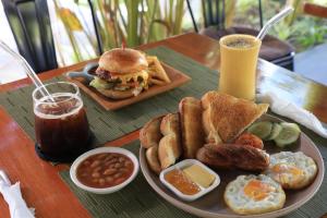 a plate of breakfast food with a sandwich and french fries at OHANA, Panglao Resort. in Panglao Island