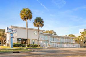 a building with palm trees and a hotel at Fin's Inn & Suites in Myrtle Beach