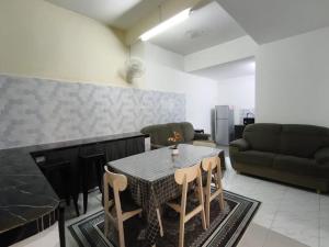 a living room with a table and a couch at FAs KLIA Guesthouse, 4BR 4 AC , NEAR KLIA, NILAI in Sepang