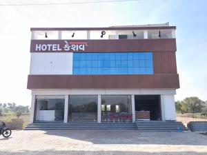 a hotel building with a motorcycle parked in front at Hotel Keshav in Dhorīmanna