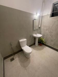 a bathroom with a toilet and a sink at Dew home stay in Dickwella