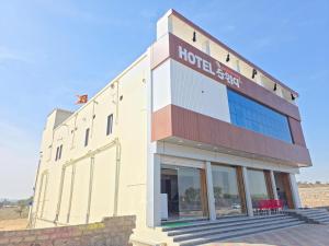 a building with a hotel sign on the side of it at Hotel Keshav in Dhorīmanna