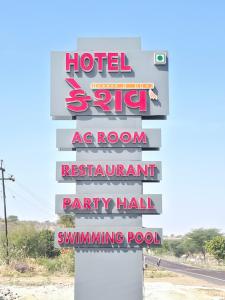 a sign for a hotel on the side of a road at Hotel Keshav in Dhorīmanna