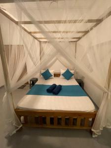 a bed in a tent with blue pillows on it at Dew home stay in Dickwella