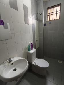 a white bathroom with a toilet and a sink at FAs KLIA Guesthouse, 4BR 4 AC , NEAR KLIA, NILAI in Sepang +12 photos