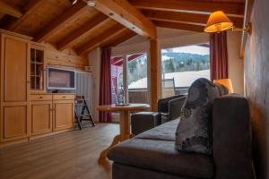 a living room with a couch and a television at Ferienhotel Starennest in Schindelberg
