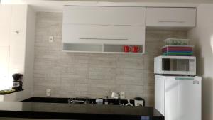 a kitchen with a microwave and a refrigerator at Apartamento Campos dos Goytacazes de 3 quartos com ar condicionado in Campos dos Goytacazes