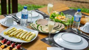 a table with plates of food and glasses of milk at Vilona Nature Villa in Dambulla +65 photos