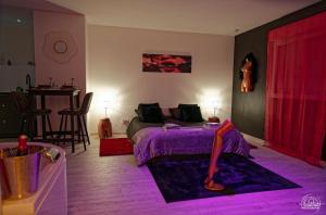 a bedroom with a purple bed and a table at LoveRoom Les Folies Douces & Spa in Nancy