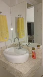a bathroom with a white sink and two mirrors at Apartamento Campos dos Goytacazes de 3 quartos com ar condicionado in Campos dos Goytacazes