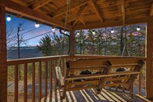 a swing on a porch with a view at Somewhere In Time cabin in Sevierville