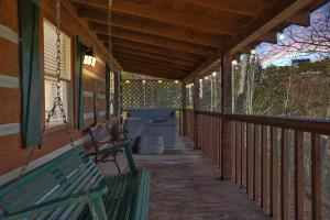 a porch of a house with a bench and toilets at Somewhere In Time cabin in Sevierville