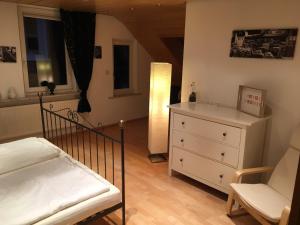 a bedroom with a bed and a dresser and a chair at Ferienwohnung im Herzen Bad Wildbads in Bad Wildbad
