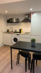 a kitchen with a black table and chairs in a kitchen at Five House 14B in Porto