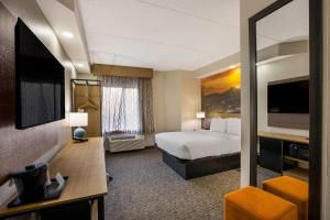 a hotel room with a bed and a television at Clarion Pointe Sevierville-Pigeon Forge in Sevierville
