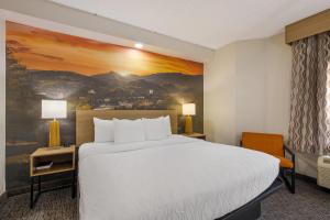 a hotel room with a large bed and a painting at Clarion Pointe Sevierville-Pigeon Forge in Sevierville +51 photos