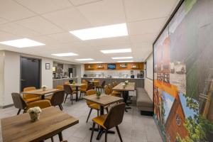a restaurant with tables and chairs and a large wall at Clarion Pointe Sevierville-Pigeon Forge in Sevierville
