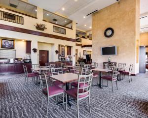 a restaurant with tables and chairs and a tv at Comfort Suites near NASA - Clear Lake in Webster