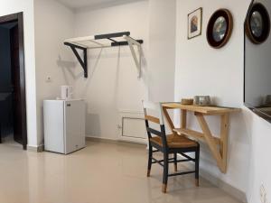 a room with a table and a chair and a refrigerator at Le cocon éclatant in Sfax