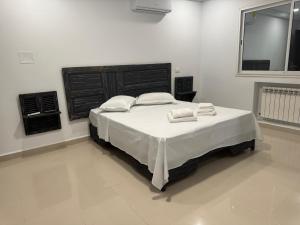 a bedroom with a bed with two towels on it at Le cocon éclatant in Sfax