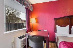 a room with a bed and a desk and a window at Econo Lodge Williamsburg Historic Area in Williamsburg