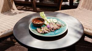 a plate of food with meat on a table at Visama Explorer Nan in Ban Huai Luk +29 photos