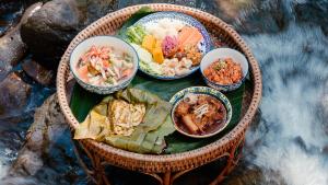 a table with bowls of different foods on it at Visama Explorer Nan in Ban Huai Luk