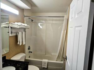 a bathroom with a shower and a toilet and a sink at Rodeway Inn & Suites in Kamloops +104 photos