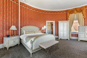 a bedroom with a bed in a room with orange walls at Windsor Hotel, an Ascend Collection Hotel in Americus +46 photos