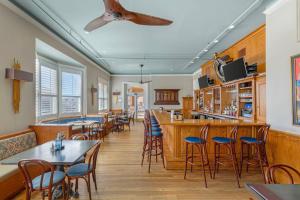 a restaurant with tables and chairs and a bar at Windsor Hotel, an Ascend Collection Hotel in Americus