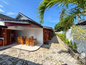 a patio of a house with a table and chairs at Trytan Gerupuk Homestay in Bumbang