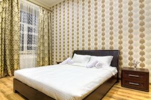 リヴィウにあるAlfa Apartments Grygorenkoのベッドルーム1室(白いシーツ付きのベッド1台、窓付)
